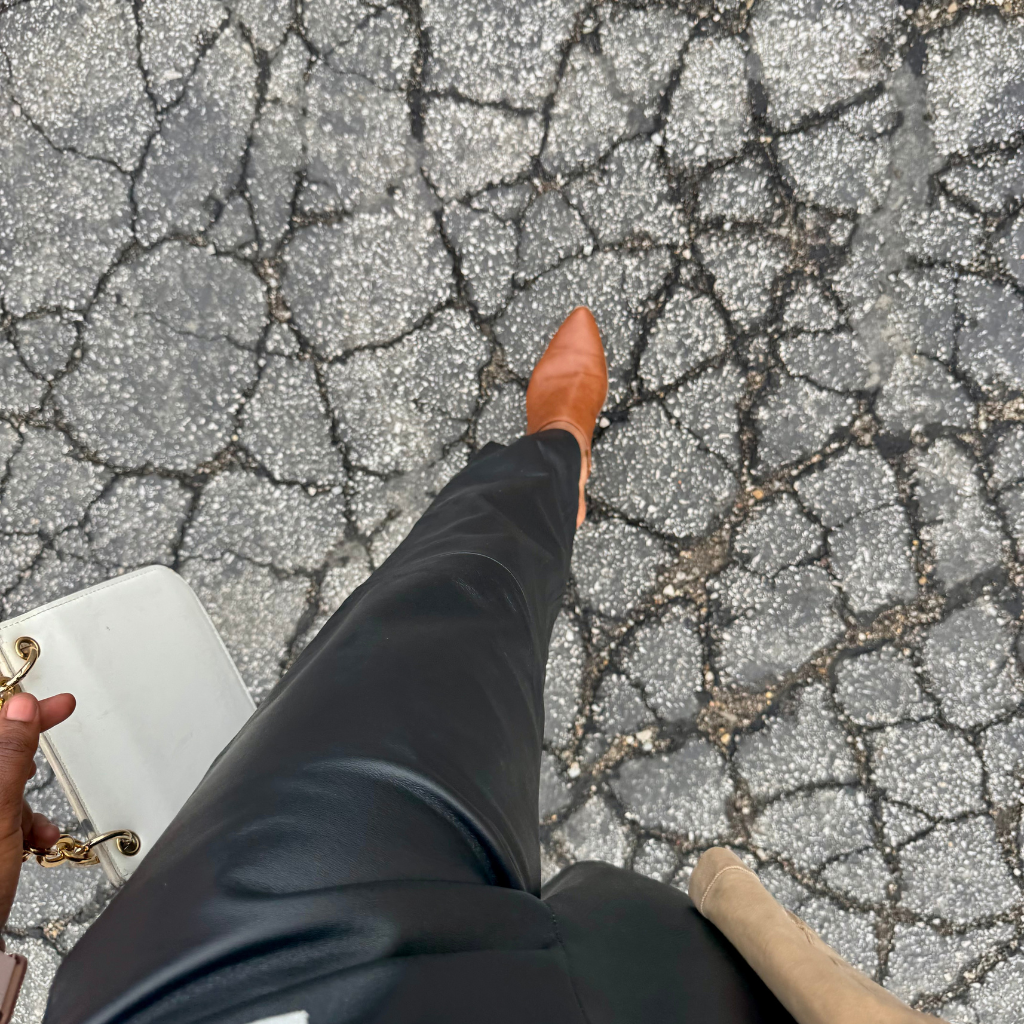 woman wearing black leather pants with brown leather sandals